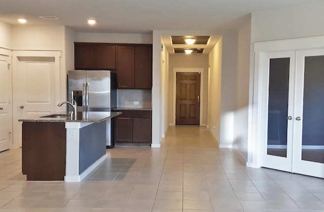 16342 Rockdale Landing Dr, Hockley, TX 77447 - kitchen with a sink, light tile patterned floors, french doors, dark stone countertops, and dark brown cabinetry