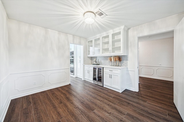 10014 Moorberry Ln, Houston, TX 77080 - indoor dry bar featuring beverage cooler, a decorative wall, backsplash, dark wood-type flooring, and a wainscoted wall