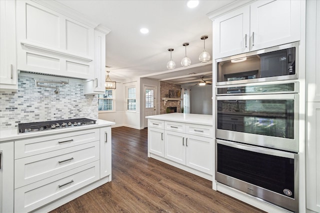 10014 Moorberry Ln, Houston, TX 77080 - kitchen featuring appliances with stainless steel finishes, ceiling fan, backsplash, white cabinets, and recessed lighting