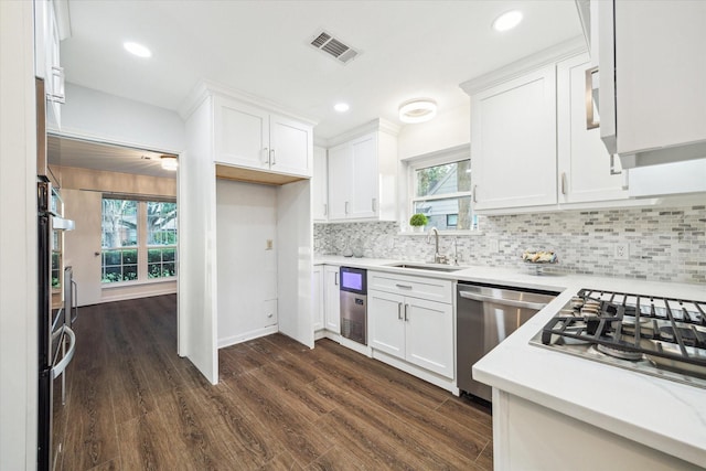10014 Moorberry Ln, Houston, TX 77080 - kitchen featuring stainless steel appliances, a sink, light countertops, dark wood-type flooring, and white cabinetry