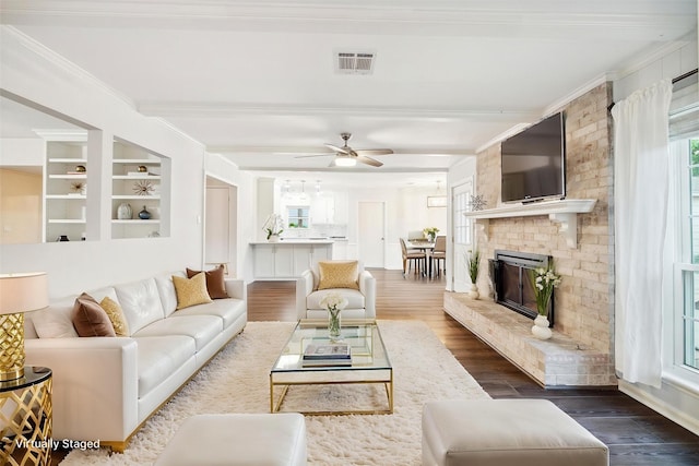 10014 Moorberry Ln, Houston, TX 77080 - living room featuring ornamental molding, beam ceiling, dark wood-style flooring, a ceiling fan, and a fireplace