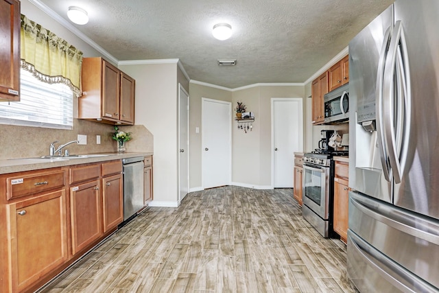 10911 Crosby Field Ln, Houston, TX 77034 - kitchen with appliances with stainless steel finishes, light wood-style flooring, light countertops, a textured ceiling, and a sink