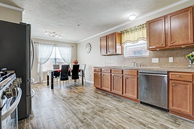 10911 Crosby Field Ln, Houston, TX 77034 - kitchen with appliances with stainless steel finishes, light countertops, a textured ceiling, crown molding, and brown cabinets