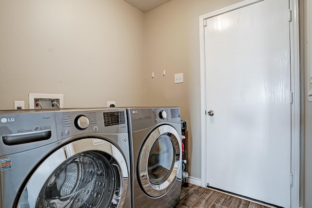 10911 Crosby Field Ln, Houston, TX 77034 - laundry area featuring washing machine and clothes dryer, wood finished floors, and baseboards