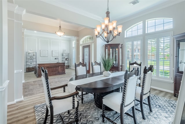 dining space featuring light wood-type flooring, crown molding, and a chandelier