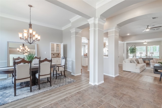 dining area with ornate columns, a ceiling fan, ornamental molding, arched walkways, and baseboards