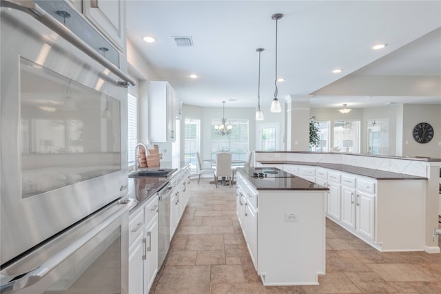 kitchen featuring a sink, a large island, stone tile floors, appliances with stainless steel finishes, and recessed lighting