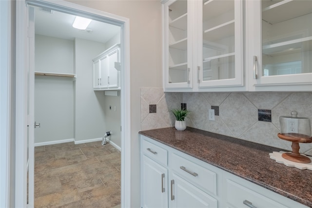 laundry room with baseboards and stone finish floors