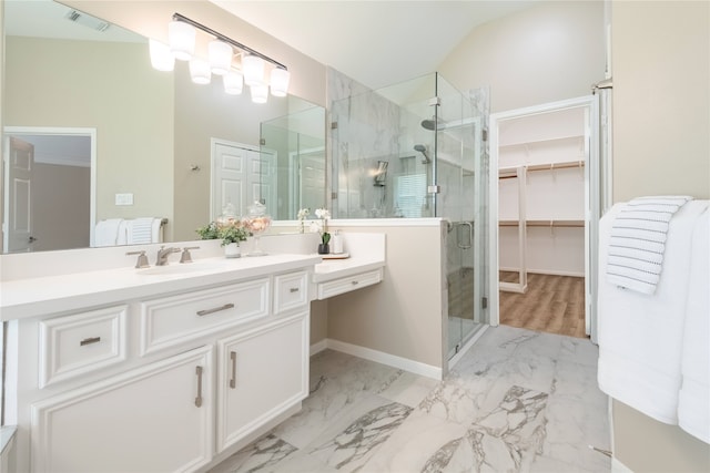 bathroom with a shower stall, vanity, a spacious closet, marble finish floors, and baseboards