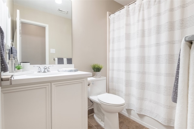 full bathroom with toilet, vanity, and tile patterned flooring