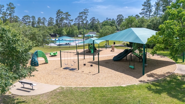 community playground featuring a lawn and view of scattered trees