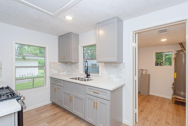 2425 E Fayle St, Baytown, TX 77521 - kitchen with gray cabinets, a sink, stainless steel gas stove, light wood finished floors, and recessed lighting