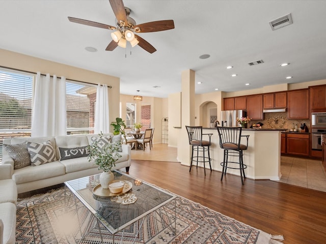 22603 Blanefield Ct, Tomball, TX 77375 - living room featuring wood finished floors, ceiling fan, arched walkways, and recessed lighting
