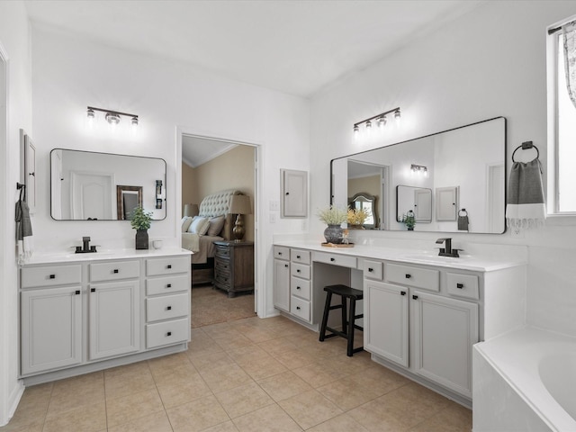 22603 Blanefield Ct, Tomball, TX 77375 - bathroom featuring two vanities, a bath, and tile patterned floors