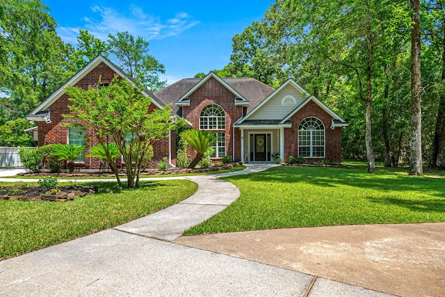 traditional-style home with brick siding, a front lawn, and a shingled roof