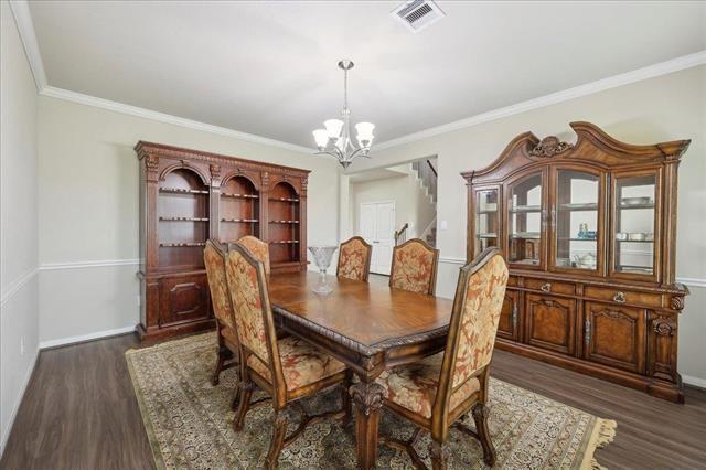 2498 Diamond D Dr, Beaumont, TX 77713 - dining room with a chandelier, dark wood-type flooring, crown molding, and baseboards