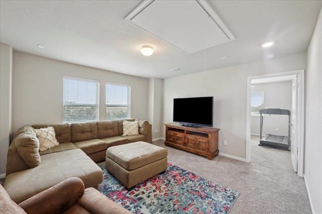 2498 Diamond D Dr, Beaumont, TX 77713 - carpeted living room with attic access and baseboards