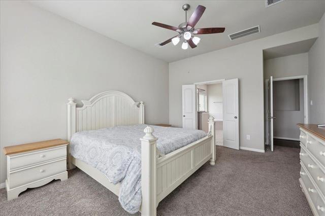 2498 Diamond D Dr, Beaumont, TX 77713 - carpeted bedroom featuring baseboards, a ceiling fan, and connected bathroom
