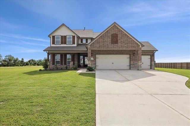 2498 Diamond D Dr, Beaumont, TX 77713 - view of front of house with a front yard, driveway, an attached garage, and brick siding