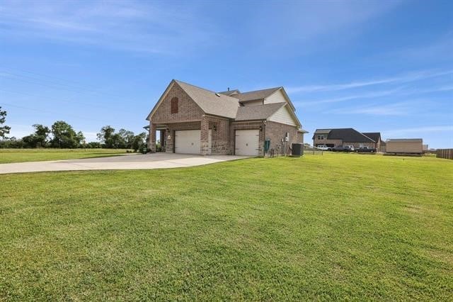 2498 Diamond D Dr, Beaumont, TX 77713 - view of home's exterior featuring concrete driveway, a lawn, brick siding, and an attached garage