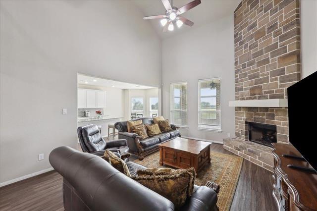 2498 Diamond D Dr, Beaumont, TX 77713 - living area featuring a ceiling fan, dark wood-type flooring, baseboards, a fireplace, and high vaulted ceiling