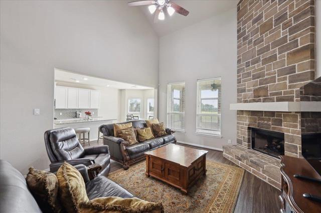2498 Diamond D Dr, Beaumont, TX 77713 - living room with a ceiling fan, wood finished floors, high vaulted ceiling, a fireplace, and baseboards