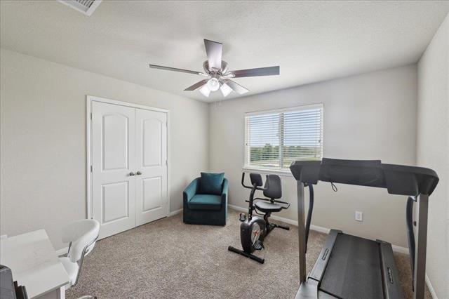 2498 Diamond D Dr, Beaumont, TX 77713 - workout room with a ceiling fan, carpet flooring, and baseboards