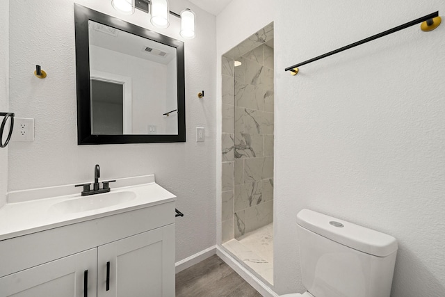 404 Glenmore Dr, Pasadena, TX 77503 - bathroom featuring toilet, vanity, a shower stall, wood finished floors, and baseboards