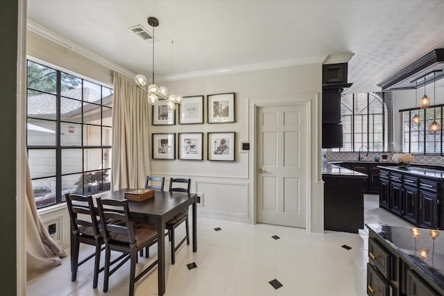 24615 Mount Auburn Dr, Katy, TX 77494 - dining space with ornamental molding, a chandelier, a decorative wall, and a wainscoted wall