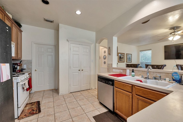 13111 Porter Meadow Ln, Houston, TX 77014 - kitchen with white appliances, arched walkways, a sink, light tile patterned floors, and a ceiling fan