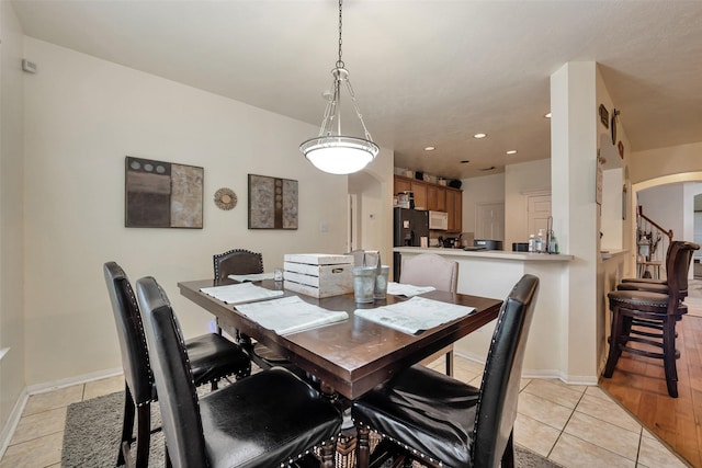 13111 Porter Meadow Ln, Houston, TX 77014 - dining area with arched walkways, light tile patterned floors, recessed lighting, and baseboards
