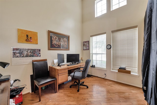 13111 Porter Meadow Ln, Houston, TX 77014 - home office with light wood-style flooring, a high ceiling, and baseboards