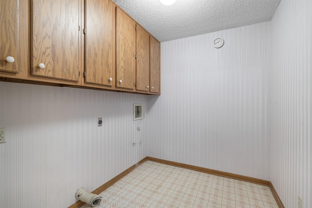 207 Oak Hill Dr, Brenham, TX 77833 - laundry room with hookup for an electric dryer, hookup for a washing machine, cabinet space, a textured ceiling, and baseboards