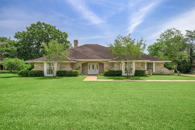 207 Oak Hill Dr, Brenham, TX 77833 - ranch-style home featuring a front yard, a chimney, and brick siding