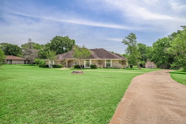 207 Oak Hill Dr, Brenham, TX 77833 - single story home with a storage unit, a front lawn, and an outbuilding
