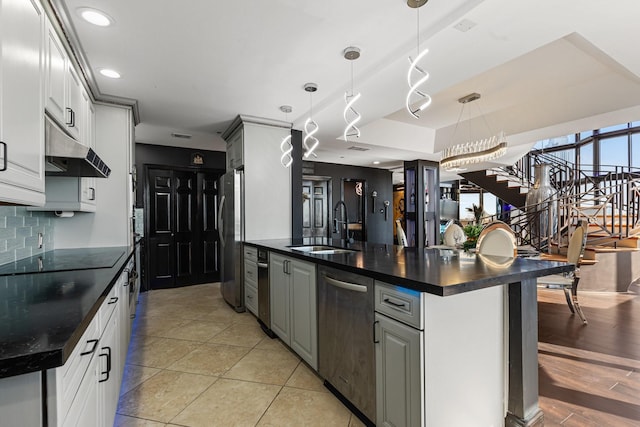 3350 Mccue Rd Unit 2404, Houston, TX 77056 - kitchen with appliances with stainless steel finishes, under cabinet range hood, a sink, decorative backsplash, and decorative light fixtures