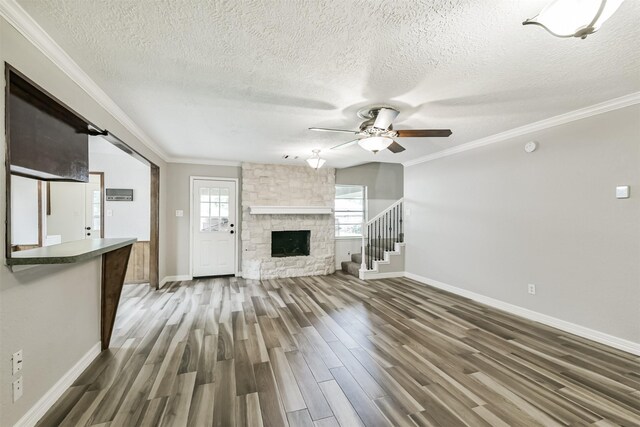 28902 Twisted Oak Dr, Shenandoah, TX 77381 - unfurnished living room with a textured ceiling, wood finished floors, baseboards, ceiling fan, and crown molding