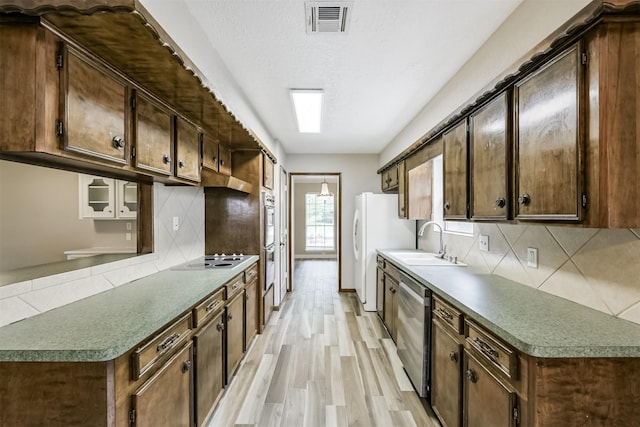 28902 Twisted Oak Dr, Shenandoah, TX 77381 - kitchen featuring white appliances, a sink, tasteful backsplash, and light wood-style flooring