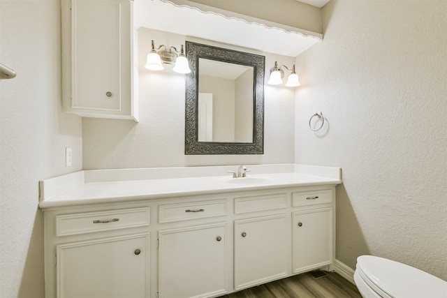 28902 Twisted Oak Dr, Shenandoah, TX 77381 - bathroom featuring vanity, toilet, wood finished floors, a textured wall, and baseboards