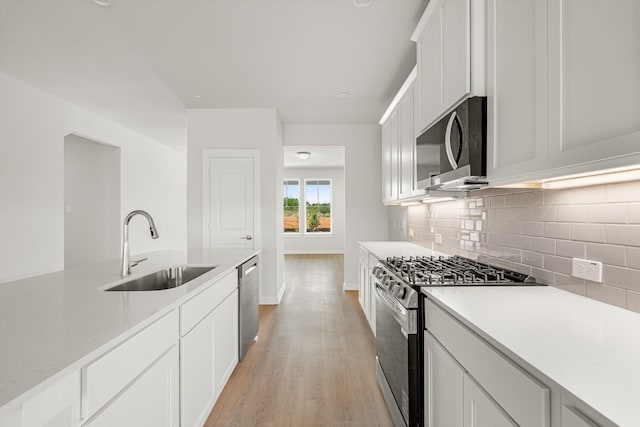 33019 School Hill Rd, Fulshear, TX 77441 - kitchen with stainless steel appliances, a sink, light wood-type flooring, and light countertops