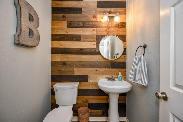13907 Pawnee Trails Dr, Cypress, TX 77429 - half bath with wood walls, toilet, and a textured wall