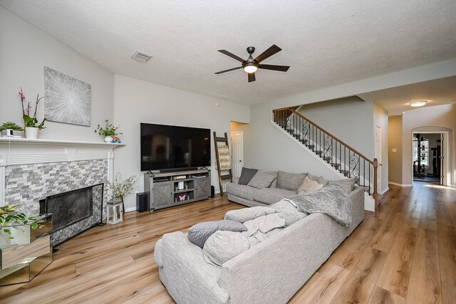 13907 Pawnee Trails Dr, Cypress, TX 77429 - living room with a ceiling fan, stairway, wood finished floors, arched walkways, and a textured ceiling