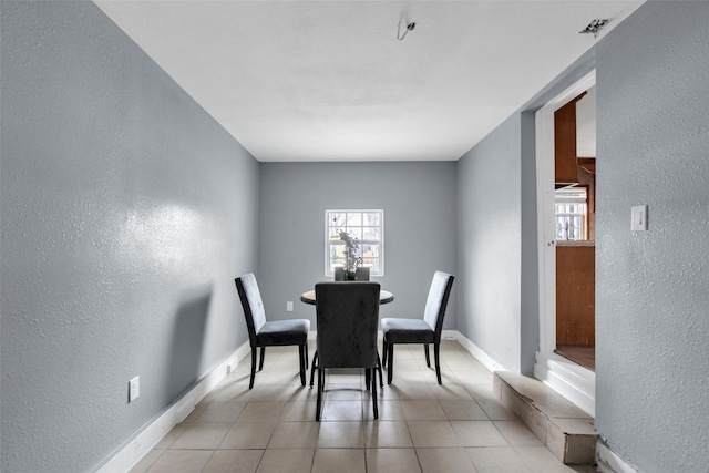1016 Apache St, Houston, TX 77022 - dining space featuring a textured wall, healthy amount of natural light, light tile patterned flooring, and baseboards