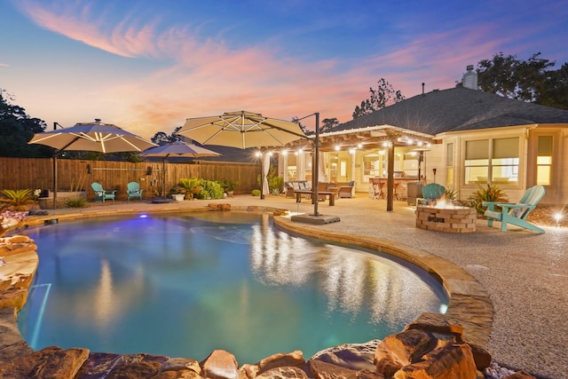 6123 Cypress Way Dr, Magnolia, TX 77354 - pool at dusk with an outdoor fire pit, a patio, and fence