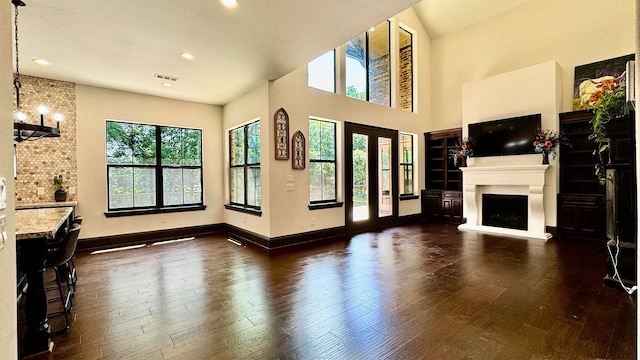 4818 Lake Village Dr, Fulshear, TX 77441 - unfurnished living room featuring a fireplace with raised hearth, dark wood-style flooring, baseboards, recessed lighting, and a high ceiling