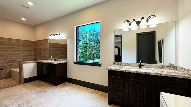 4818 Lake Village Dr, Fulshear, TX 77441 - full bathroom with two vanities, a bathtub, recessed lighting, and tile patterned floors