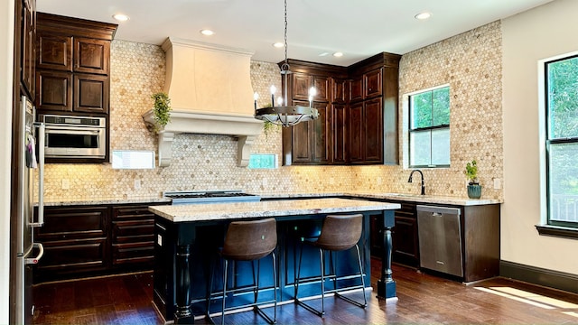 4818 Lake Village Dr, Fulshear, TX 77441 - kitchen with stainless steel appliances, dark wood finished floors, a center island, dark brown cabinets, and a sink