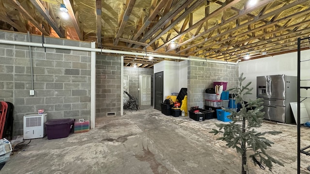 4818 Lake Village Dr, Fulshear, TX 77441 - unfinished basement with stainless steel fridge and concrete block wall
