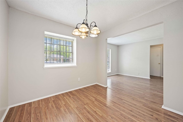 11750 Murr Way, Houston, TX 77048 - spare room featuring a chandelier, wood finished floors, baseboards, and a textured ceiling