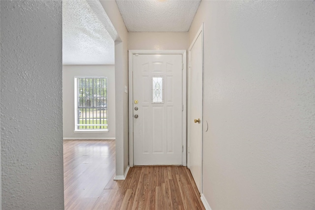 11750 Murr Way, Houston, TX 77048 - doorway to outside with wood finished floors, a textured wall, a textured ceiling, and baseboards